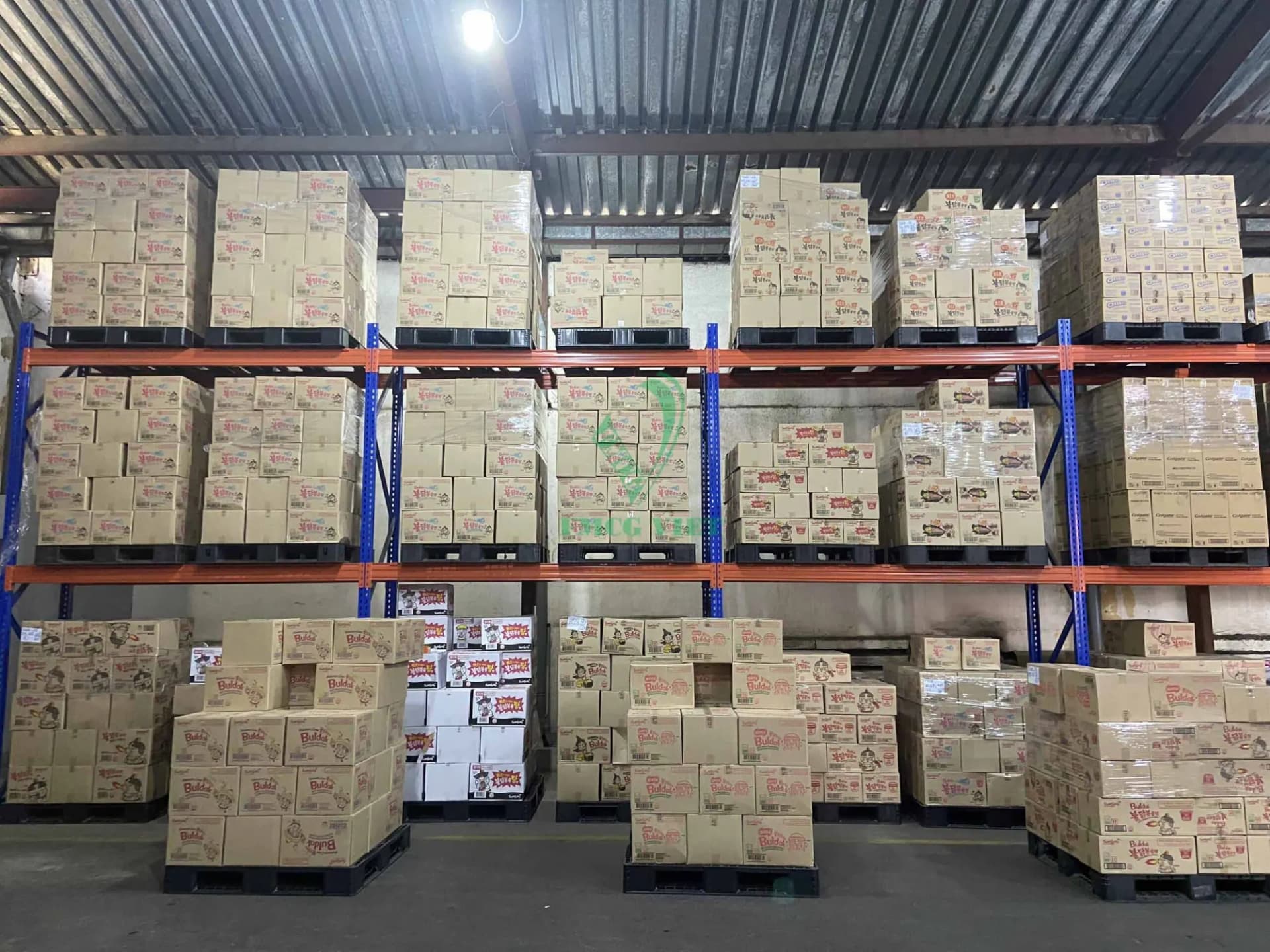 Pallets of noodle cartons stored on blue and orange warehouse racking